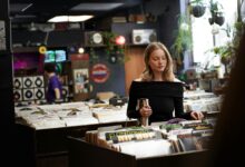 Young woman browsing vinyl records in a cozy vintage music store.