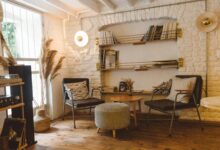 Inviting modern rustic living room featuring armchairs, an ottoman, and a stylish bookshelf.