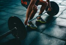 Man performing a deadlift exercise in a gym, demonstrating strength and fitness.